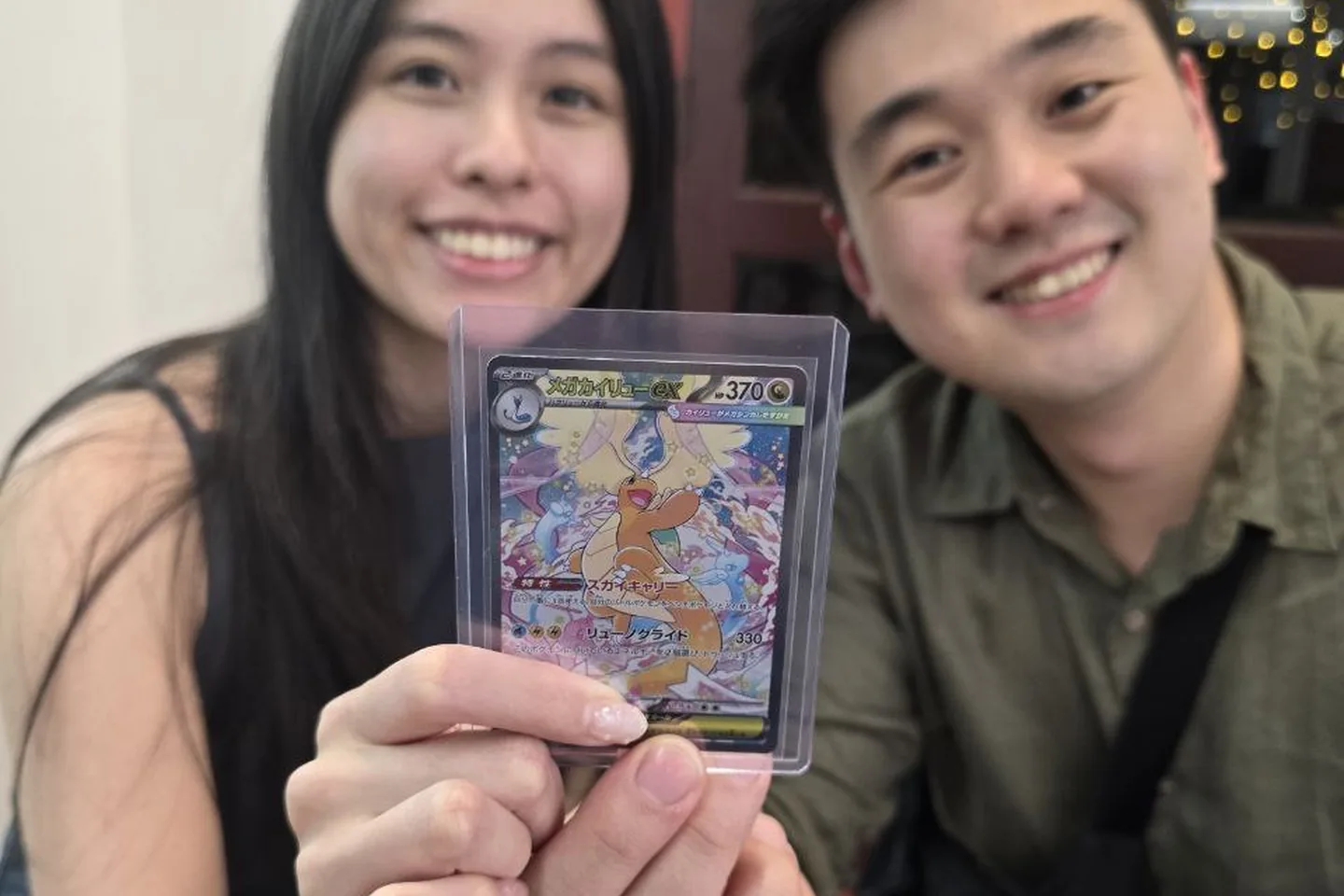 A couple showing off a Dragonite pull together at the table.