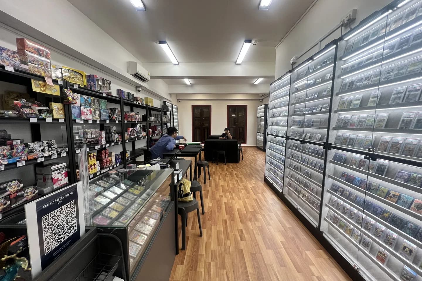 The Cards Central interior with lit display walls and play tables.